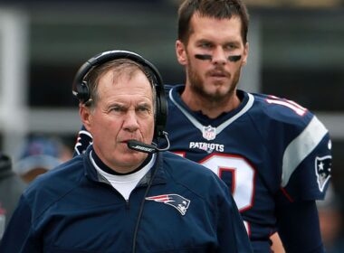 Bill Belichick discussing strategies with his team during a game.