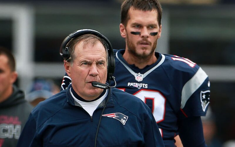 Bill Belichick discussing strategies with his team during a game.